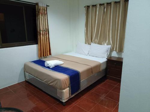 a small bedroom with a bed and a window at Kata S.T House 2 in Phuket