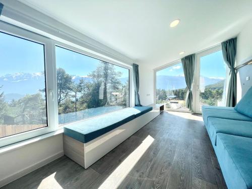 a living room with a blue couch and large windows at Holiday Home SKY Chalet by Interhome in Imst