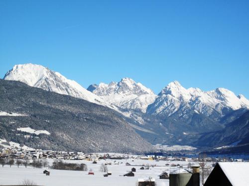 a snowy mountain range with a town in the foreground at Holiday Home Sky-Chalet by Interhome in Imst