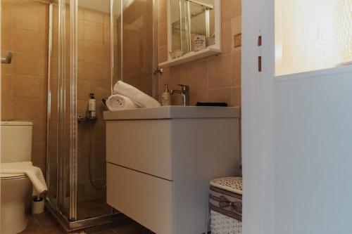 uma casa de banho com um lavatório e um chuveiro em Pool and Sea View Apartments em Aghia Marina
