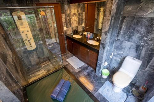 a bathroom with a shower and a toilet and a sink at Amazing Beachfront Villa in Ko Lanta