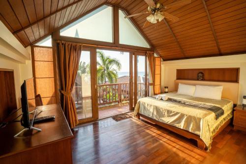 a bedroom with a bed and a large window at Amazing Beachfront Villa in Ko Lanta