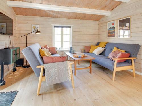 - un salon avec un canapé bleu et une table dans l'établissement Holiday Home Eckhart - 30km from the sea in Western Jutland by Interhome, à Toftlund