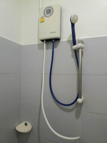 a shower with a blue hose attached to a wall at Kata S.T House 2 in Phuket