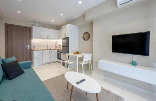 a living room with a couch and a tv on a wall at CHE BELLO LUXURY APARTMENTS in Preveza