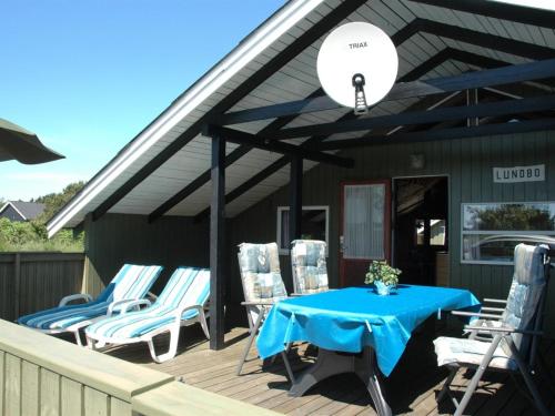 a deck with a blue table and chairs on a house at Holiday Home Nilda - 1km from the sea in Western Jutland by Interhome in Vejers Strand
