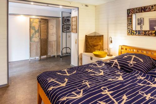 Schlafzimmer mit einem Bett mit einer blauen und weißen Bettdecke in der Unterkunft Modernes Landapartment in Seevetal