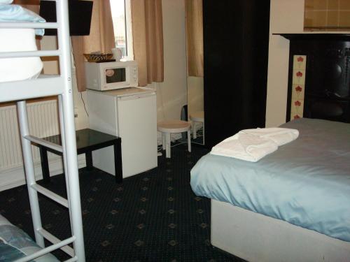 a hotel room with a bunk bed and a ladder at Forest Gate Hotel - Free Parking limited spaces in London