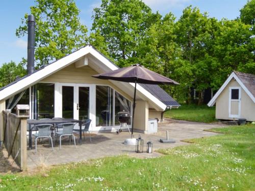 une maison avec une table et un parasol dans l'établissement Holiday Home Hailka in SE Jutland by Interhome, à Give