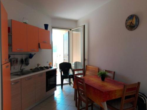 a kitchen with a wooden table and a dining room at Grazioso appartamento terrazzo e wi-fi near Otranto in Casamassella