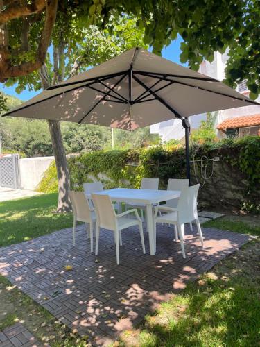 a table and chairs under a large umbrella at Villa Cycas in Ischia