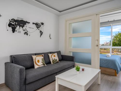 uma sala de estar com um sofá e um mapa do mundo na parede em Apartment La Torre by Interhome em Torremolinos