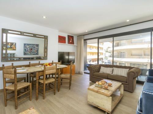 uma sala de estar com uma mesa e um sofá em Apartment Galan by Interhome em Sant Antoni de Calonge