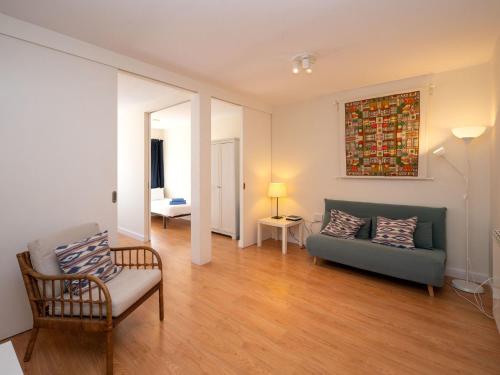 ein Wohnzimmer mit einem Sofa und einem Stuhl in der Unterkunft Apartment Sagrada Familia- Rossello by Interhome in Barcelona