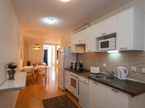 eine Küche mit weißen Schränken und einer Arbeitsplatte in der Unterkunft Apartment Sagrada Familia- Rossello by Interhome in Barcelona