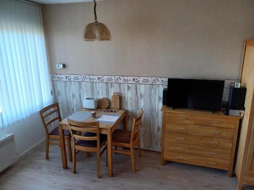 a dining room with a table and chairs and a television at Ferienwohnung Conny am Südstrand Familie Bach in Burgtiefe auf Fehmarn 