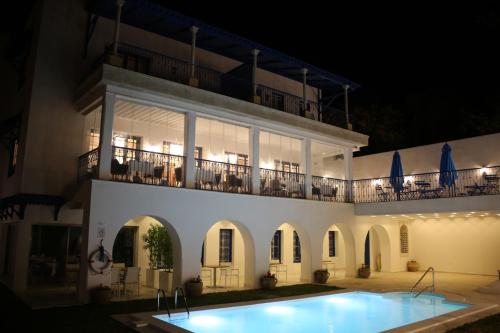 eine Villa mit einem Pool in der Nacht in der Unterkunft La Menara Hotel & SPA in Sidi Bou Saïd