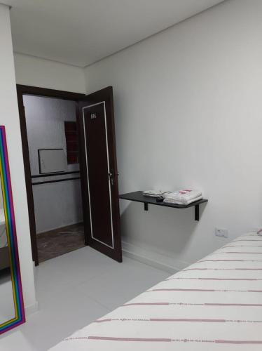 a room with a door and a shelf on the wall at Hotel Flor da Vila Mariana in Sao Paulo