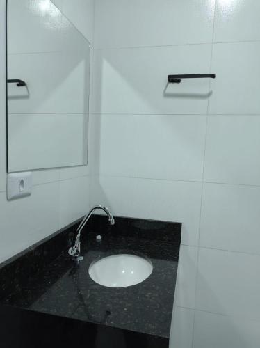 a bathroom with a sink and a mirror at Hotel Flor da Vila Mariana in Sao Paulo