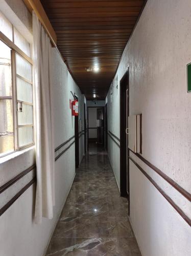 an empty hallway in a building with a window at Hotel Flor da Vila Mariana in Sao Paulo