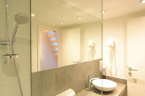 a bathroom with a shower and a sink and a mirror at Maverick Apartments in Budapest