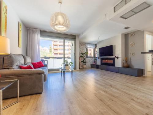 a living room with a couch and a tv at Apartment Barcelona by Interhome in Torredembarra