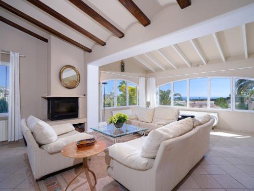 a living room with white furniture and a fireplace at Villa Marita by Interhome in Moraira