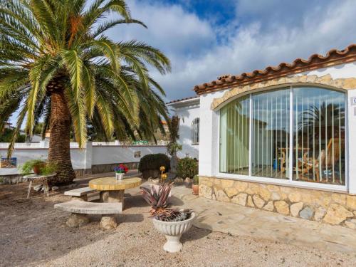 a patio with a table and a palm tree at Villa Villa Resi by Interhome in Miami Platja