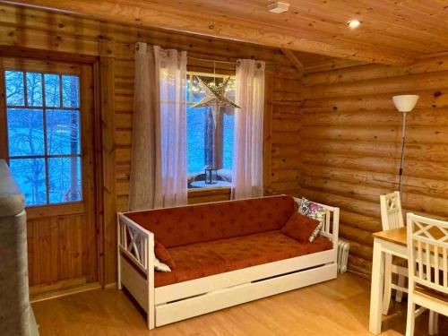 ein Wohnzimmer mit einem Sofa in einem Blockhaus in der Unterkunft Villa Maaria, LaatuLomat in Juva