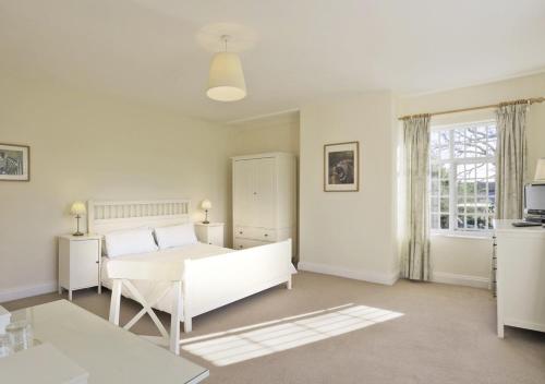 a white bedroom with a bed and a window at Park Farm House in Wangford