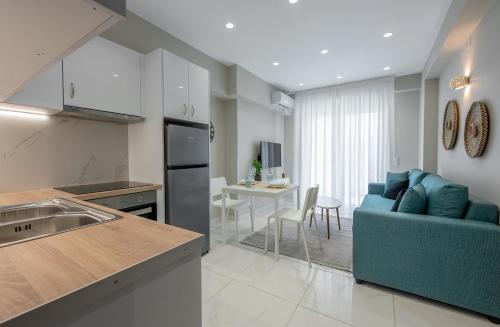 a kitchen and a living room with a blue couch at NK Luxury Apartments in Preveza