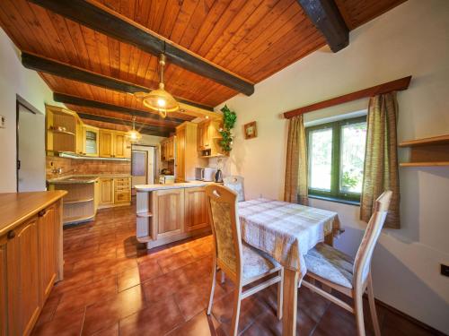 una cucina con soffitti in legno, tavolo e sedie di Holiday Home Hodkovice by Interhome ad Adršpach