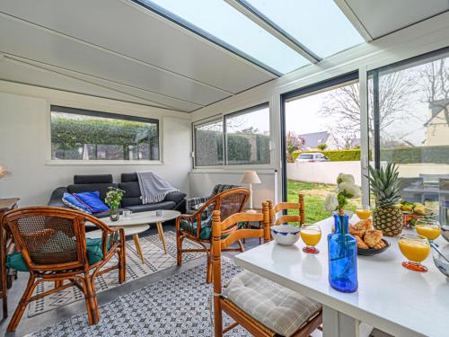 - un salon avec une véranda, une table et des chaises dans l'établissement Holiday Home L'Armoricaine by Interhome, à Saint-Philibert