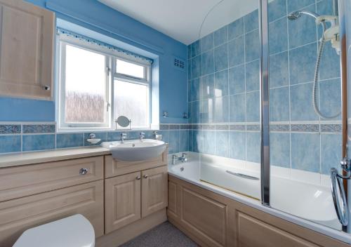 La salle de bains est pourvue d'une baignoire, d'un lavabo et d'une douche. dans l'établissement Poppy Corner, à Southwold