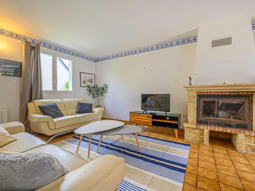 ein Wohnzimmer mit einem Sofa und einem Kamin in der Unterkunft Holiday Home Le Large by Interhome in Saint-Philibert