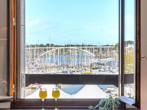 una ventana con vistas al puerto deportivo y 2 copas de vino en Apartment Le Quai by Interhome en La Trinité-sur-Mer