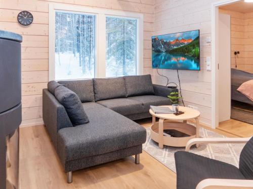 ein Wohnzimmer mit Sofa und Tisch in der Unterkunft Holiday Home Mäkitie 2 by Interhome in Aikkila