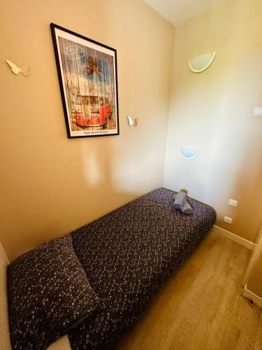 une chambre avec un lit avec un tableau sur le mur dans l'établissement La Résidence du Golf de Deauville, à Deauville