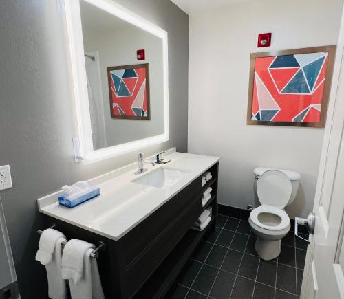 ein Badezimmer mit einem Waschbecken, einem WC und einem Spiegel in der Unterkunft Comfort Inn Emporia in Emporia