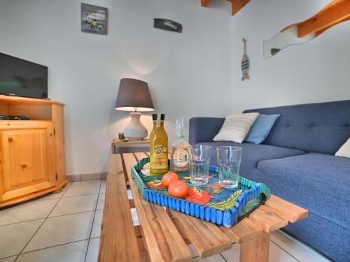 un salon avec un canapé bleu et une table dans l'établissement Holiday Home Le Clos de la Forêt by Interhome, à Dolus-d'Oléron