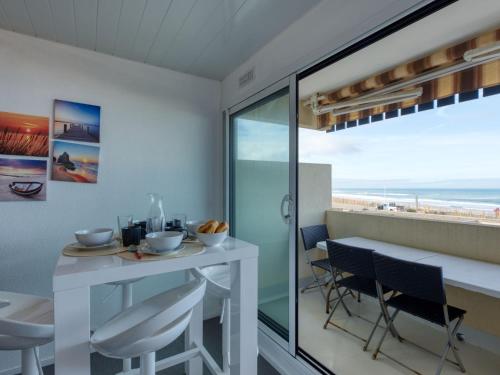 a dining room with a view of the beach at Apartment Les Océanides-19 by Interhome in Lacanau-Océan