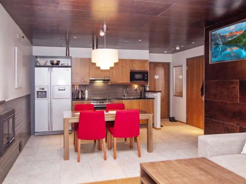 a kitchen with a wooden table and red chairs at Holiday Home Tahko spa junior suite orange a 10 by Interhome in Tahkovuori