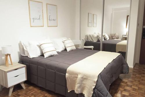 1 dormitorio con 1 cama grande y espejo en FREN0102 Increíble Depto en Recoleta de 2 ambientes en Buenos Aires