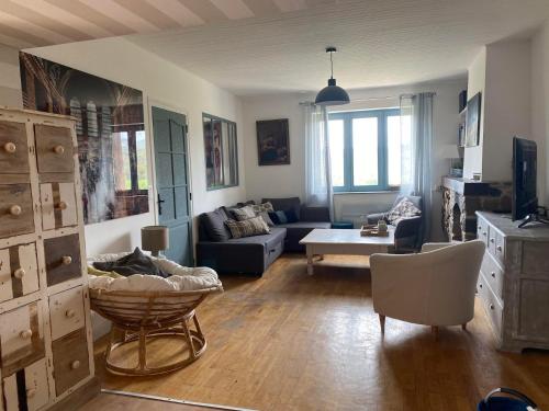 salon z kanapą i stołem w obiekcie Maison sur cour w mieście Courzieu