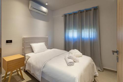 a bedroom with a bed with white sheets and a window at La Villa del Mare - Nafpaktos Beach in Nafpaktos