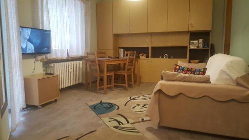 uma sala de estar com um sofá, uma mesa e uma televisão em Bardonecchia, monolocale, ottima posizione. em Bardonecchia