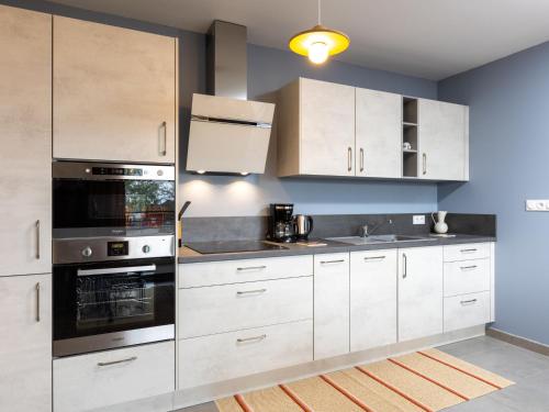 une cuisine avec des armoires blanches et des appareils en acier inoxydable dans l'établissement Apartment Résidence Newquay-2 by Interhome, à Dinard