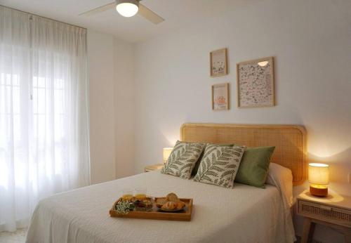 Un dormitorio con una cama con una bandeja de comida. en Apartamento El Sol Naciente, en La Herradura