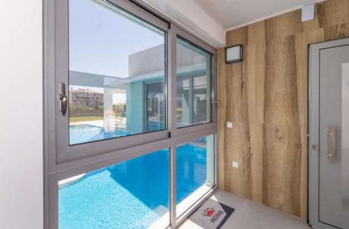 a house with a swimming pool seen through a window at La Villa del Mare - Nafpaktos Beach in Nafpaktos