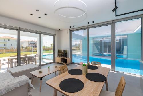 a living room with a table and chairs and a pool at La Villa del Mare - Nafpaktos Beach in Nafpaktos